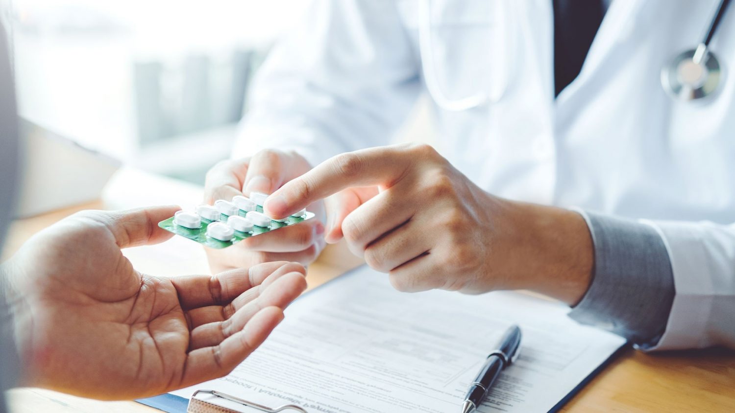 Doctor giving minoxidil tablets to a patient for hair loss treatment